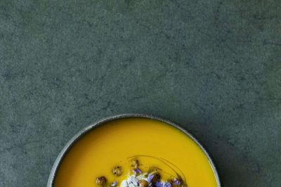 Gulerodssuppe med kardemommeyoghurt, ristede kikærter, mandler og purløgsblomster.