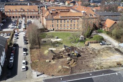 Entreprenørfirmaet KPC er gået i gang med at klargøre til byggeri af 11 såkaldte townhouses ud mod Skolegade og Pontoppidansvej. Det er det første byggeri på sygehusgrunden, som vil forandre udseende i de kommende år, når regionshospitalet er flyttet ud til Gødstrup. Foto: Tom Laursen