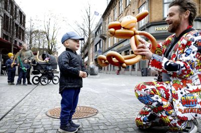 Ballonmand Peter Møller Hansen vakte opsigt i sit iøjnefaldende jakkesæt, men naturligvis mest på grund af de sjove ballondyr. Her har han lavet en ballonabe til Lukas Bruun Neigaard på to år fra Snejbjerg. Foto: Henrik Ole Jensen