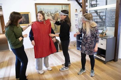 Museumsinspektør Ditte Skov Jensen (t.v.) beundrer kjolen på Emilie Skov, mens museets kommunikationsansvarlige, Maja Theodoraki, og Julie Lolk (t.h.), der er museumsinspektør og leder af Klosterlund Museum, ser til. Foto: Tom Laursen