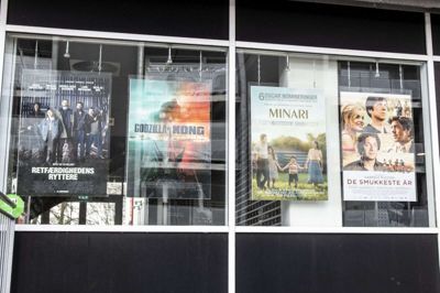 Dette billede af vinduerne hos Ikast Bio er taget lørdag 8. maj i forbindelse med en artikel om den første »genåbningsweekend« efter lang tids corona-nedlukning. Få dage efter blev filmen »Godzilla vs. Kong« taget af programmet, fordi Ikast Bio har tilsluttet sig en landsdækkende protestaktion mod to amerikanske filmselskaber, som har ændret voldsomt i biografernes muligheder for at have en periode med eneret på nye film, men samtidig skal biograferne betale samme pris som tidligere. Foto: Tom Laursen