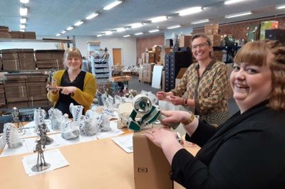 Design og Handelshuset i Videbæk har succes med at pakke og sende ordrer direkte til modtagere på vegne af giveren. Bettina Damholdt (i midten) er ejer. Emma Lunde Høgh (t.h) og Kristina Kjærgaard Hansen hjælper til i pakkeriet. Til nytår regner Bettina Damholt med, at der er to mere ansat i den afdeling. Foto: Jens Kristian Lynderup