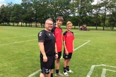 De to landsholdsaspiranter Rasmus Eriksen (i midten) og Elias Christensen (t.h.) med holdleder Brian »Bomber« Larsen. Drengene fortalte, at de ikke er blevet bange for at spille fodbold, efter de så deres idol kollapse under kampen i lørdags. foto: Ida TRue Berg