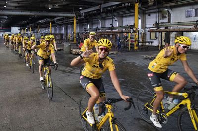 Trods 150 kilometer i benene, var der overskud til smil og vink på den lille omvej gennem fabrikshallen i Fasterholt. Foto: Jørn Deleuran