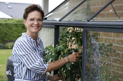Vibeke Sandfeld er vild med udelivet om sommeren. I haven nyder hun gerne et glas hvidvin og en god bog. Foto: Tom Laursen