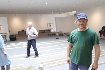 Søren Engsted under opsætningen af sin udstilling på Vestjyllands Kunstpavillon. I baggrunden er det formanden for opsætningsudvalget, Jens Fjord, i samtale med kurator Anne Zychalak Stolten, der har inviteret Søren Engsted til Vestjyllands Kunstpavillon. Foto: Jesper Wind