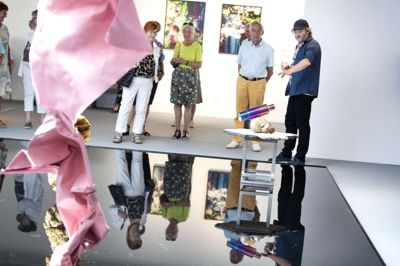 Søren Engsted med kasket fortæller Erling Damgaard, formand for Vestjyllands Kunstpavillon, om hans tanker bag værkerne i udstillingen »If the Future isn’t Bright at least it’s Colorful« ved lørdagens fernisering. Foto: Tom Laursen