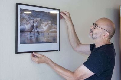 Gunner Borg fra Fotogruppen MidtWest retter lige på et af de fotografier gruppen i øjeblikket udstiller på Vorgod Ældrecenter. Foto: Leif Bengtsson