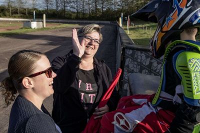 Karin Bæk giver Malthe Mariboe en high-five. Drengen er klar igen, efter han er styrtet på banen. Karin Bæk er den, der samler trådene under træningen af de yngste kørere. Foto: Jørn Deleuran