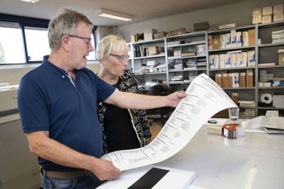 Noget af det første, som GRC/Trykstuen A/S producerede til kommunalvalget 2021, var denne kandidatliste. Grafiker Torben Smedegaard og bogtrykker UIla de Wolff kigger listen igennem. Foto: Tom Laursen