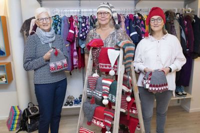 I øjeblikket sælger Mødrehjælpens butik i Fonnesbechsgade hjemmestrikkede nissehuer til fordel for sårbare familier. Men der er behov for meget mere hjælp for at give børn fra trængte familier en god jul. Fonden Mødrehjælpen uddeler hvert år julehjælp, og det er nu, man skal ansøge om at komme i betragtning. Her er det fra venstre en af nissehuestrikkerne, 73-årige Marie Slumstrup fra Tjørring, der også er mor til frivillig Marianne Nickelsen (t.h.), mens det er frivillig Charlotte Andersen i midten. Frivillige er der også stort behov for flere af i Mødrehjælpens lokalforening i Herning. Foto: Tom Laursen