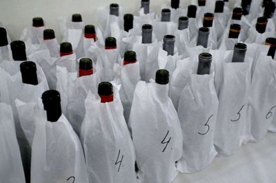 Kandidaterne til årets julevin blev naturligvis pakket ind i anonyme, hvide omslag, inden smagerne "satte tænderne" i dem. Foto: Henrik Ole Jensen