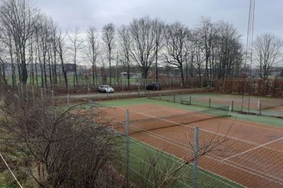 De to kunstbaner ved Sunds Tennisklub skal bygges om til to overdækkede baner til padeltennis. Fornyelsen af tennisanlægget er en del af en ny samlet plan for udnyttelsen af det grønne område mellem tennisbanerne og Multicenter Sunds, der ses i baggrunden. Foto: Jesper Wind