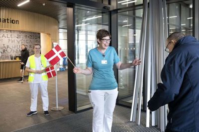 Afdelingssygeplejerske Pia Dalgaard (forrest) og sygeplejerske Linda Birkbak Rahbek havde både flag og de store smil fremme, da de i går tog imod dialysepatienterne, der skulle modtage deres behandling i Gødstrup for første gang. Foto: Tom Laursen