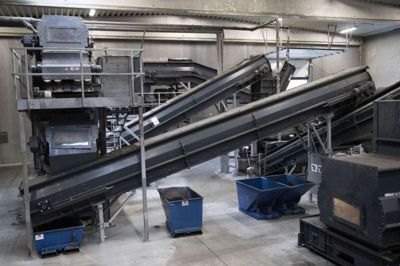 Her ses de speciallavede transportbånd, som udgør en vigtig del af produktionslinjen hos Re-Match. I den ene ende løftes kunstgræsbaner op med en truck, og herefter bliver banerne findelt, tørret og sorteret, så man genskaber originaldelene gummi, sand og fibre. Foto: Malene Tswai
