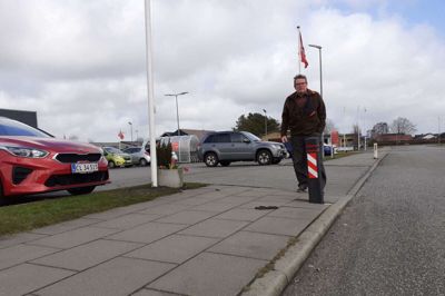 Ole Bjerg Sørensen ved den udskældte pæl i fortovet ud for ABC Lavpris i Tjørring. Den bliver skiftet ud med en ny pæl, der er til at se for bilisterne og ikke laver buler i bilerne. Foto: jesper Wind
