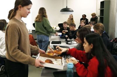 Emma Lihle Thomsen i baggrunden mellem et par venner i 8.B. Denne gang blev sejren fejret, ved at læreren havde købt fastelavnsboller til hele klassen. Foto: Malene Tswai