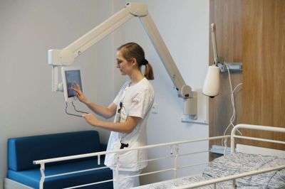 Ipad’en er monteret, så skærmen både kan vendes mod sengen og mod sofaen. Her er det sygeplejerske Pernille Kiib Liseborg, som håndterer Ipad’en. Foto: Malene Tswai