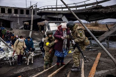 Ukrainske soldater hjælper en ældre dame med at komme over en ødelagt bro. Dimitar Dilkoff/Ritzau Scanpix