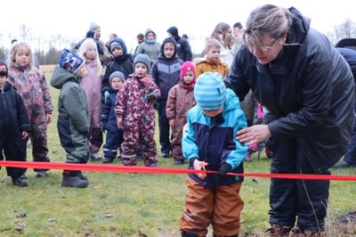 Ivan på fire år klippede den røde snor ved indvielsen af børnehusets lille frugtplantage. Børnehusets leder Kirsten Bøgh Pedersen hjalp til. Foto: Privatfoto