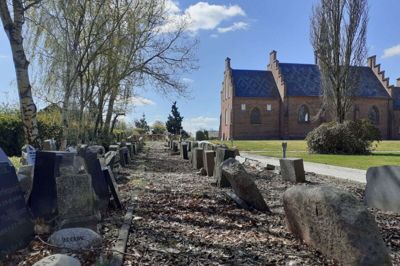 Gravstenene fra sløjfede gravsteder på Fasterholt Kirke er samlet ét sted i det såkaldte lapidarium. Der skal laves et nyt lapidarium, hvor reglerne om, at gravstene skal stå op i en ret vinkel, kan overholdes. Foto: Jesper Wind
