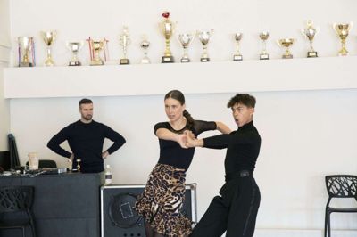 14-årige Victoria Hestbek Sørensen og hendes jævnaldrende partner, Marcos, på dansegulvet under overvågning af den otte-dobbelte verdensmester Bjørn Bitsch. Det unge par drømmer om også selv at fejre en eller flere VM-titler i fremtiden. Foto: Malene Tswai