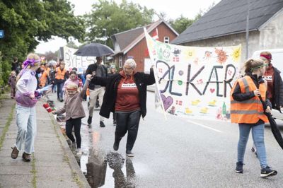 Mellem 65 og 70 voksne indledte byfesten i Kølkær med at gå i et optog gennem byen med bannere. Foto: Malene Tswai