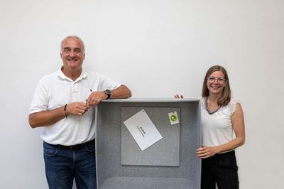Søren Sonne, administrerende direktør, og Lone Ditmer, marketing manager, poserer med et af møblerne, en reol, der er fremstillet af Dansk Wiltons tæpper. En prototype, der skal være med til at sikre virksomheden en plads i fremtidens bæredygtige marked. Foto: PR-foto