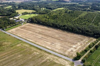 Der er et stykke fra, hvordan jordarealet ser ud nu, til det bliver til en golfbane. Først skal greens markeres, og siden skal man have både muld og større sten væk fra området. Når det er gjort, kan man begynde at lægge harpet muld ud og så græs. Foto: Tom Laursen