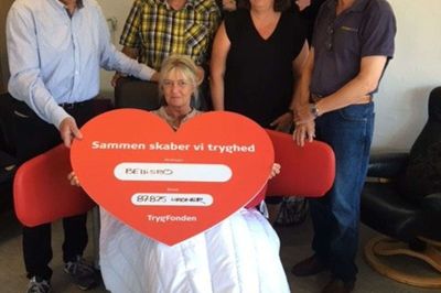 Her overrækkes donationen til Bellisbo. Fra venstre er det Kurt H. Jørgensen fra Trygfondens regionale råd i Midtjylland, Bjarne Olsen, formand for støtteforeningen Bellisbos Venner, teamleder Lene Hansen og Philip Schmann fra firmaet Wellness Nordic, der leverede stolen. I selve stolen er det Nina Nielsen, medlem af Bellisbos Venner. Foto: Hanne Munk