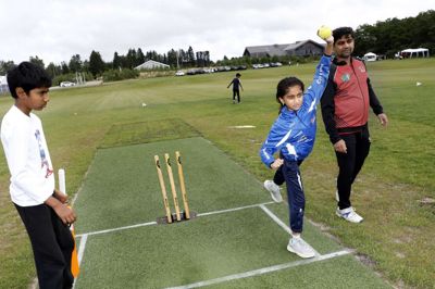 Cricket er et holdspil, hvor man spiller på en rund eller oval bane. Holdene skiftes til at være ude i marken og til at beskytte »gærdet« i midten af banen, som er den lille trækonstruktion, der ses på billedet. En spiller kaster så en lille bold mod en anden spiller, der skal forsøge at ramme den med et bat - præcis hvad spillerne ved cricket-dagen i Ikast gør her. Foto: Henrik Ole Jensen