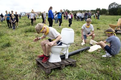 10-årige Mads Peder Kjær Nørgaard har båret en kartoffel mellem benene og slipper den ned i toilettet, mens et par af holdkammeraterne sidder klar til at smadre den, når den kommer ud af røret. Campingvognsrally-konkurrencerne ved KFUM og KFUK’s Børnefestival bød på lidt af hvert. Foto: Tom Laursen