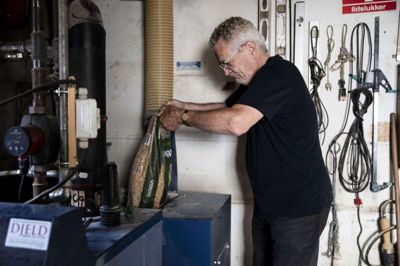 76-årige Harry Virkelyst hælder træpiller i sit pillefyr. Eller i hjernen til varmen, som han siger. Det er med energikrisen blevet en særdeles dyr fornøjelse for ham og hustruen at holde varmen. Foto: Malene Tswai