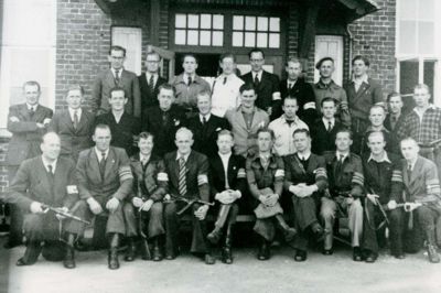 Frihedskæmpere i Ikast med frihedskæmperarmbind fotograferet maj 1945. C.C. Funk sidder på første række, nummer fem fra venstre, med hænderne foldet over knæet. Funk kom senere til politiet i Herning.
Foto: Illustration fra Hardsyssels Årbog 2022