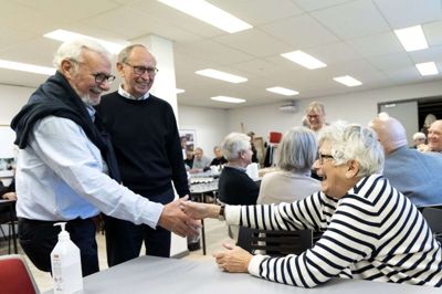 Tre af bogens forfattere hilser på hinanden ved receptionen på Ikast Bibliotek. Det er Steen Sønderborg og Sigrid Lykke, der trykker hænder, mens Niels Ole Vestergaard-Poulsen ser til. Foto: Tom Laursen