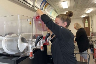 Trine Sørensen hælder »Champ Red Hindbær«smag i slushice-maskinen. - Vi har kun rød. Ellers vil de have blå i bunden, gul foroven og rød i midten. Nej! Vi har kun rød. Det er det samme med softice: Vi har kun én størrelse, forklarer hun. Foto: Marianne R. Eskildsen