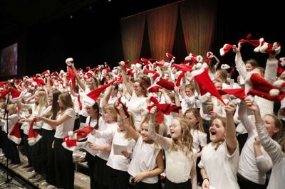 400 syngende, glade børn på scenen vifter med nissehuerne til det, der måske var den sidste Familiejulekoncert. Foto: Henrik Ole Jensen