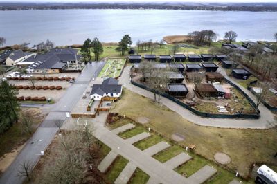 December 2022. Der er sket noget ved Sunds Søcamp de seneste to år - nederst i billedet er området til autocampere og telte. Til venstre Søgaarden, minigolfbanen og den nye informationsbygning. Ud mod søen hotelhytterne. Til marts skal 14 hotelhytter stå færdige. Foto: Tom Laursen