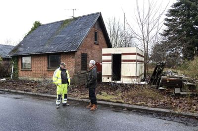 Det skal ikke rives ned, huset her på Villavej 7 i Stakroge. For hvis det engang bliver renoveret, kan det sådan set fint sælges til en børnefamilie, mener ejeren af huset, Henning Westergård Petersen (t.h.). Men en af byens borgere, Erling Bach (t.v.) har nu fået ham overtalt til, at der skal ryddes op på grunden. Foto: Tom Laursen