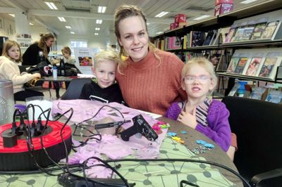 Joachim på syv år sammen med mor Anne Maria Høj Væggemose og lillesøster Mille på fire år. Alle tre hygger sig til kreadag på Aulum Bibliotek. Med er også lillesøster Rosa på 11 måneder. Hun sover dog trygt i barnevognen. Foto: Mette Christensen