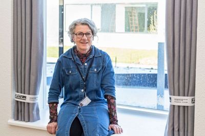 De brede vindueskarme skaber en dybde i lejligheden, der på den måde virker større, end tilfældet er. Her er det lokalleder Henriette Bruun, der nyder forårssolen og udsigten. Foto: Linna Grøn