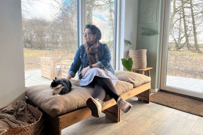 Lige her på den bløde pude med udsigt til åbne vidder - det er Marlene Juuls yndlingssted i huset. Her ses hun sammen med katten Yoda. Foto: Mette Christensen