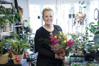 Tina Dam, indehaver af Bugges Blomster, står med en meget karakteristisk buket for trenden lige nu. Masser af farver og spræl i buketterne hitter. Her er blandt andet flere spændende blomster - som en protea, en allium og en levkøj, som med blomsterbinderens ord er sjove og anderledes. Foto: Henrik Ole Jensen