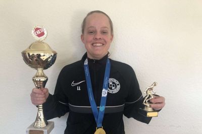 Lea Larsen iført hjemmeholdet Hammerum IFs trøje og med en lille del af sin vinder-grej: En guldmedalje fra OL-træningsturnering i Berlin, pris for årets nye spiller i Hammerum IF og en vinder-pokal fra et tidligere stævne. Foto: Thor Ølgaard Hansen