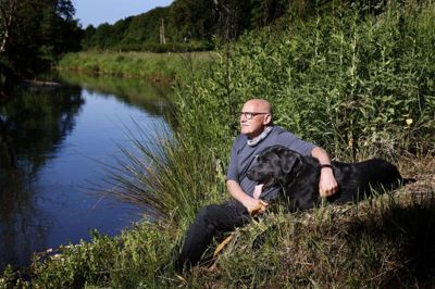 Naturen har spillet en kæmpe rolle for Knud Erik Christensen, siden han var helt lille. Den 70-årige lokalformand for Danmarks Naturfredningsforening går dagligt tre ture med labradoren Balder - blandt andet i området ved Nybro, hvor han på dette billede er fotograferet på en skøn sommerdag ved Storåen. Foto: Henrik Ole Jensen