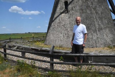 Formanden for Foreningen Uhre Mølle ved den mølle, han har kendt livet igennem. Arne Eriksen er både født og opvokset i Uhre, og det 60-årige postbud er fortsat bosat i den lille landsby med kommunens eneste fredede bygning. Foto: Flemming Thulstrup