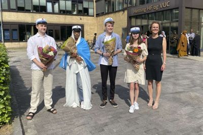 Mandag fik årets første studenter fra den to-årige HF på Herning HF & VUC deres huer. Fra venstre er det Lucas Lennart Bergdahl, Sahra Abdulahi Hassan Ahmed, Jannick Meyer Andersen og Cecilie Holmbøl Berthelsen. Yderst til højre er det rektor Anne-Mette Thorøe, som overrakte blomsterbuketter til de nyudsprungne studenter, da de traditionen tro havde fået hejst flaget foran skolen. - Det har været to gode år med gode lærere og masser af venner. Jeg er glad for, at de nu er ovre, men jeg kommer til at savne det. Efter sommerferien skal jeg starte på laborantuddannelsen i Holstebro. Det er noget, som jeg har fundet ud af, at jeg ville, imens jeg havde faget kemi på HF. Dengang, jeg startede, troede jeg, at jeg skulle læse til pædagog bagefter, fortæller Jannick Meyer Andersen, som er blandt de første nyudklækkede studenter fra uddannelsesinstitutionen. Foto: Pr-foto