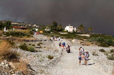 Turister blev lørdag evakueret fra området omkring byen Lindos på den græske ø Rhodos, hvor to store brande raser. Foto: Ritzau Scanpix