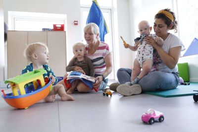 Vuggestuen i Skarrild fik under coronaen egen afdeling og indgang, og det har man fastholdt på grund af et babyboom. På billedet ses forrest Valdemar Alkærsig, pædagog Gitte Laigaard med barnebarnet Carl Laigaard på skødet og Orya Muhammad, pædagogisk assistentelev, med Christian Antonsen. foto: Henrik Ole Jensen