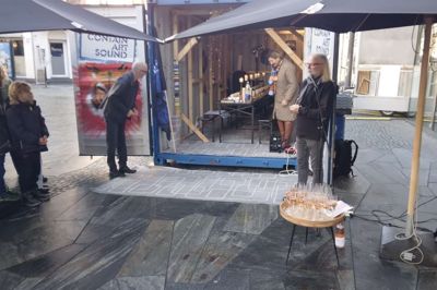 Johs. Poulsen kigger ind i containeren, hvor der er fint dækket op til de ventende Bifrost-børn. Gitte Hornshøj havde været med til at anrette både mad og bobler, mens Steen Mikkelsen står ved mikrofonen.
